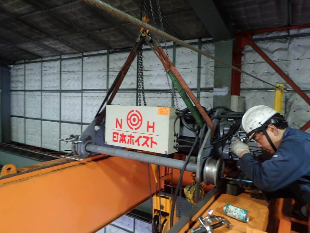 ホイストクレーンを修理する社員